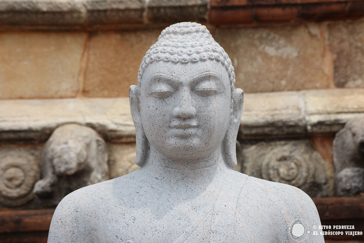 Estatua de buda junto a una estupa de Anuradhapura